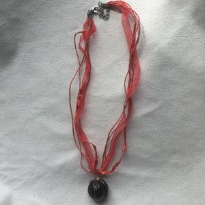 Red necklace with large circular bead